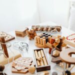 A variety of handcrafted wooden puzzles and games placed on a white table.