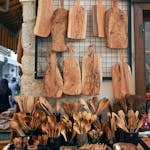 A vibrant display of handcrafted wooden kitchenware at an outdoor market stall.