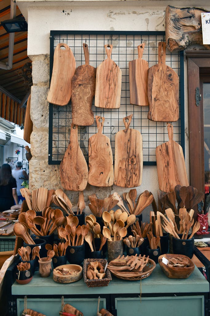 A vibrant display of handcrafted wooden kitchenware at an outdoor market stall.