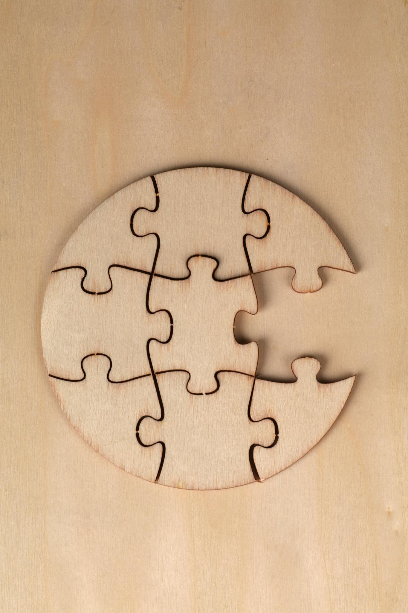 Top view of an incomplete wooden circular puzzle on a wooden surface.
