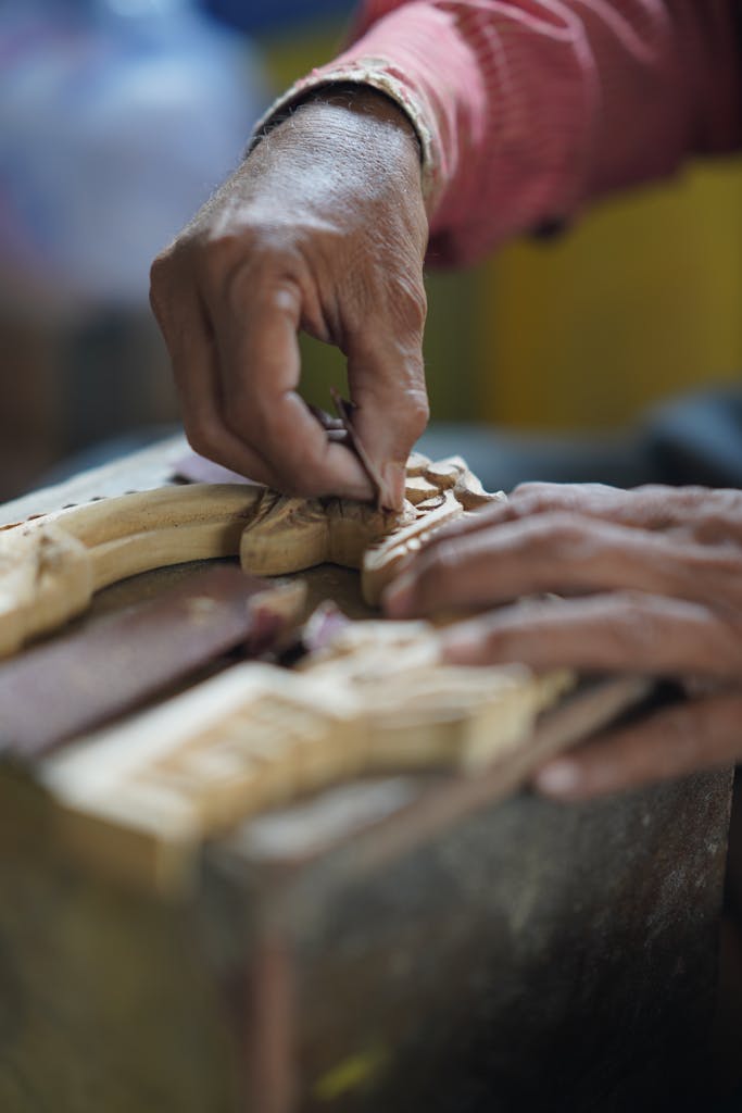 Skillful hands sculpting intricate designs into wood in Nagpur, India.